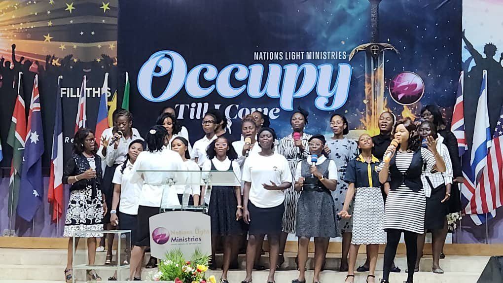 Choir ministering on stage in front of national flags