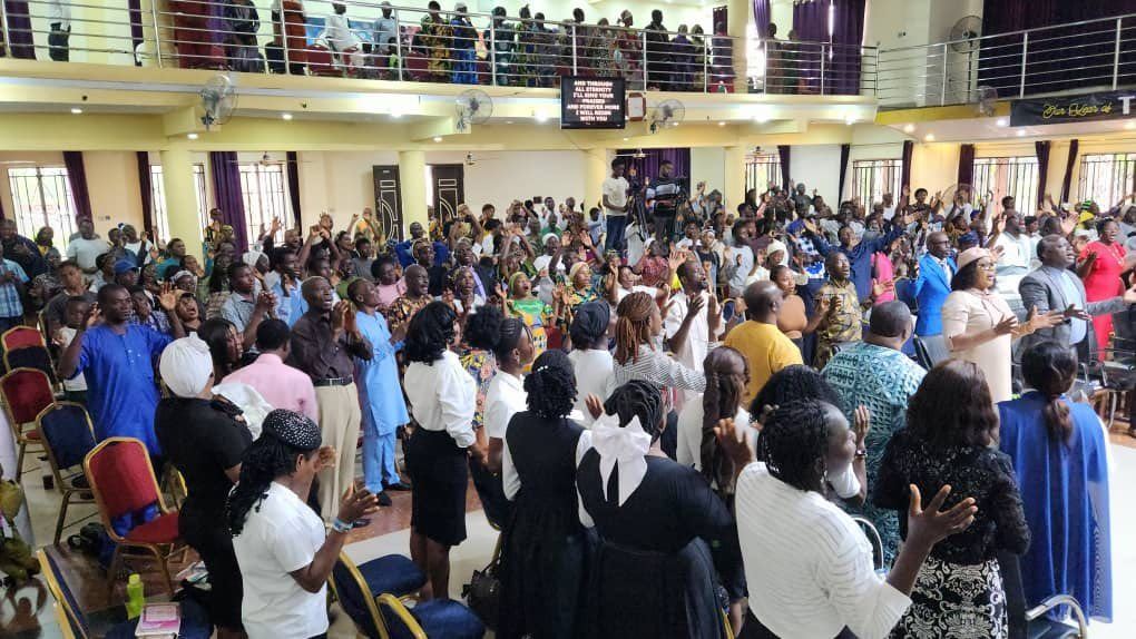 Wide view of a packed hall during worship
