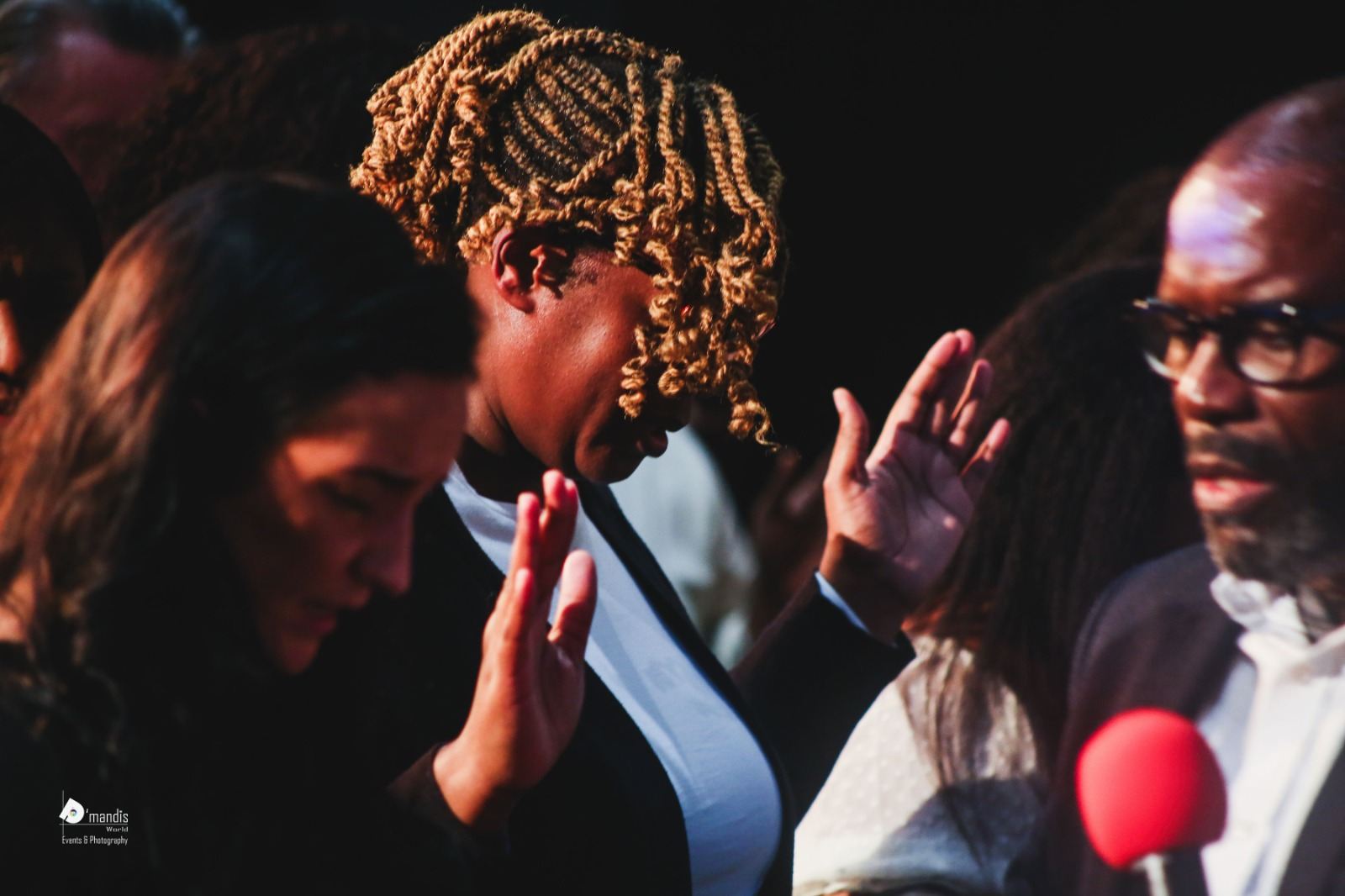 Two women praying together with hands lifted during ministry time