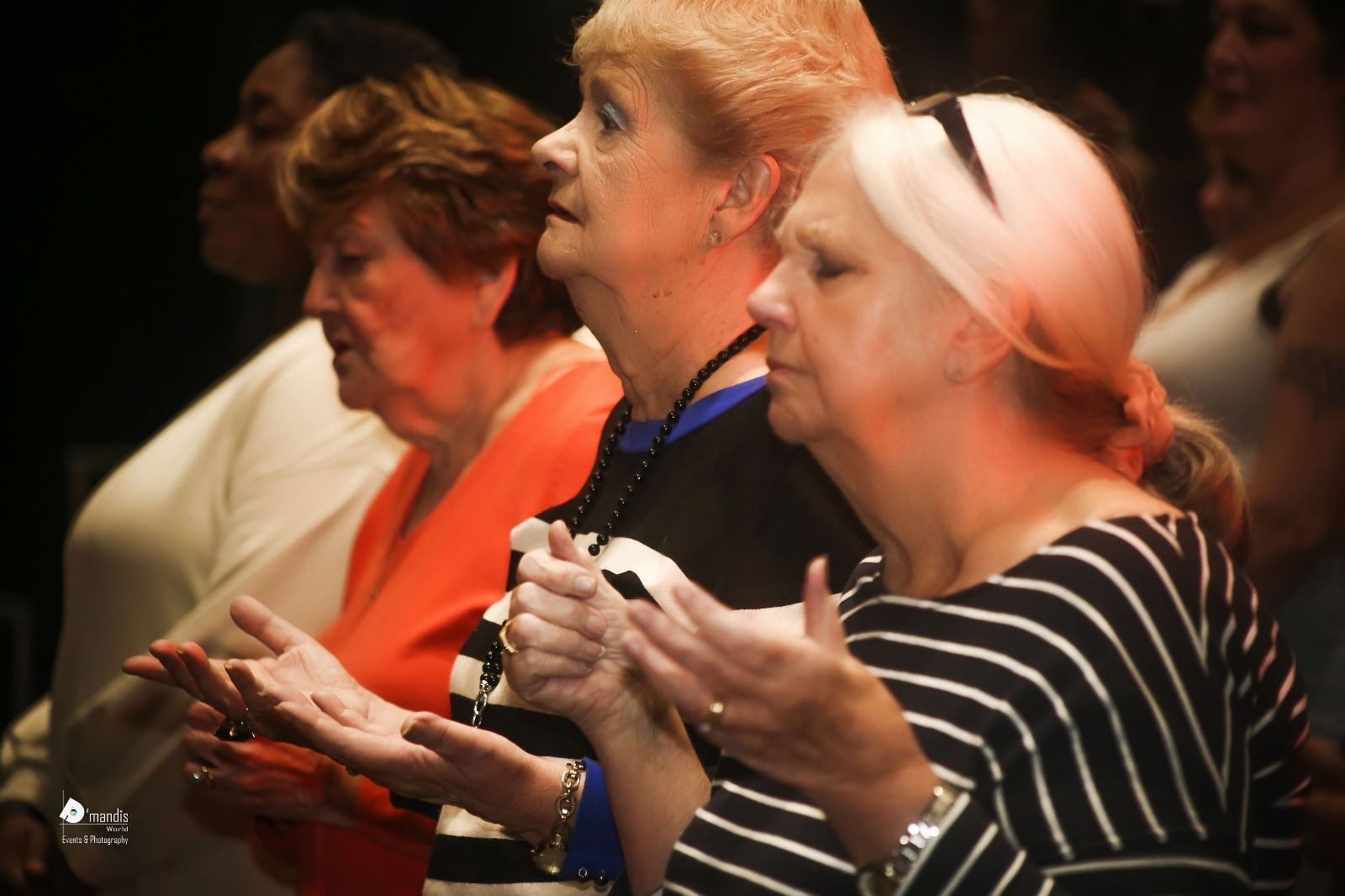 Women clapping and praying together during worship