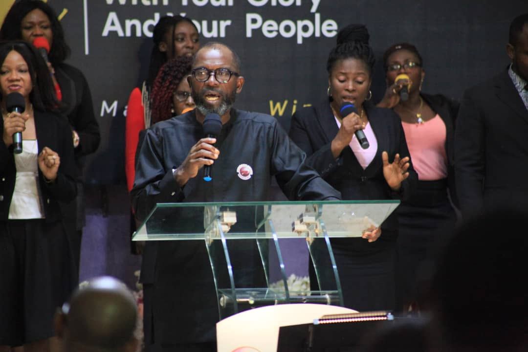 Ministers speaking together at a glass pulpit