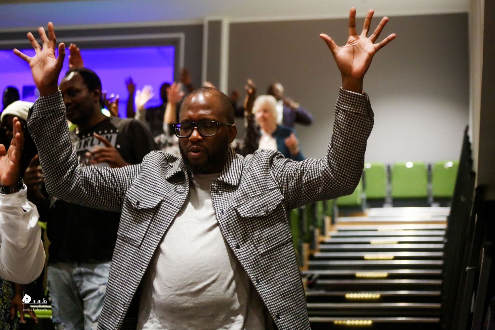 A man with both hands raised high in worship